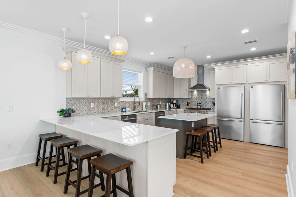 You'll love preparing meals in this bright, spacious kitchen with gleaming quartz countertops, modern stainless appliances, and a large island with bar seating for gathering.