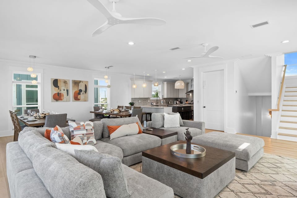 Sink into plush seating in your open-concept living space, where natural light and coastal-inspired design create a welcoming retreat for your entire group.