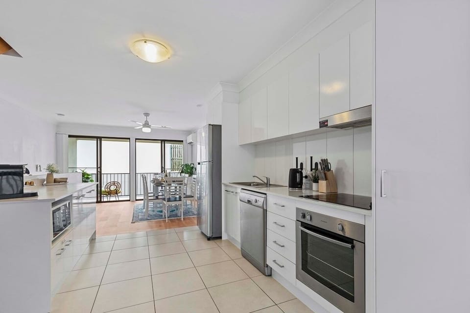 Kitchen with electric cooktop, oven, dishwasher, microwave, Nespresso.