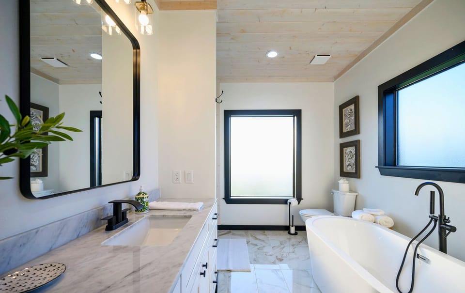 The spa-like ensuite bathroom invites you to unwind, featuring a soaking tub, beautiful finishes, and a calming, light-filled atmosphere.