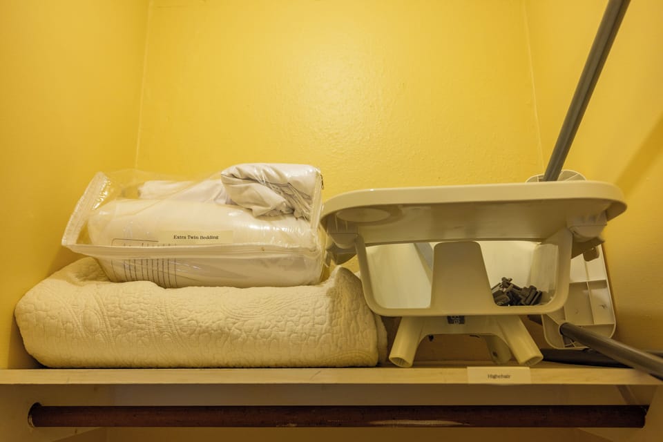 Extra sheets and highchair located in the bunk room closet