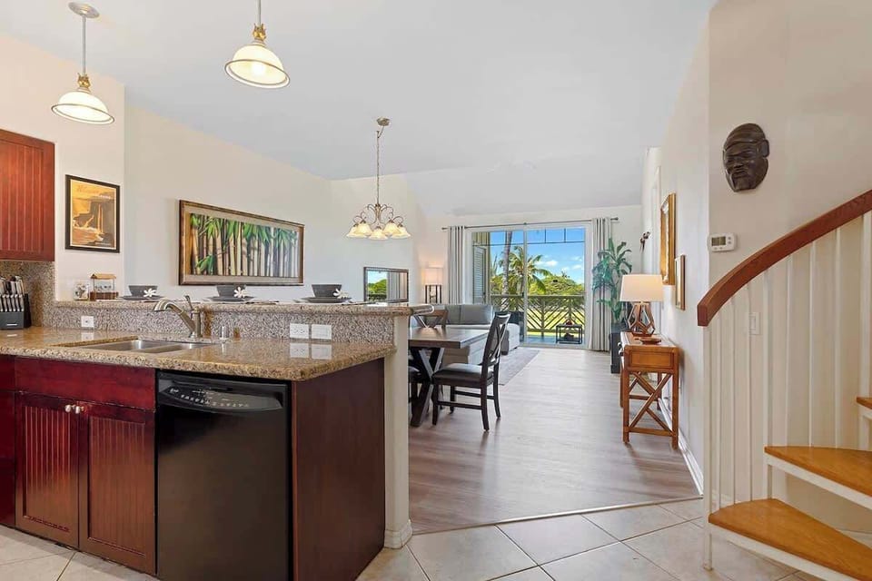 - Granite kitchen with black appliances
- Seamless flow to dining and lounge
- Pendant lights for soft ambiance