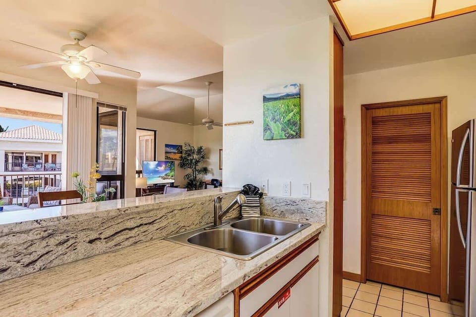 Stay connected while cooking with this open kitchen layout and views into the living room and lanai.

