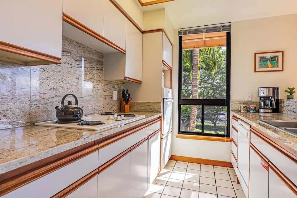 Cook with ease in this granite kitchen filled with natural light, tree views, and full amenities.

