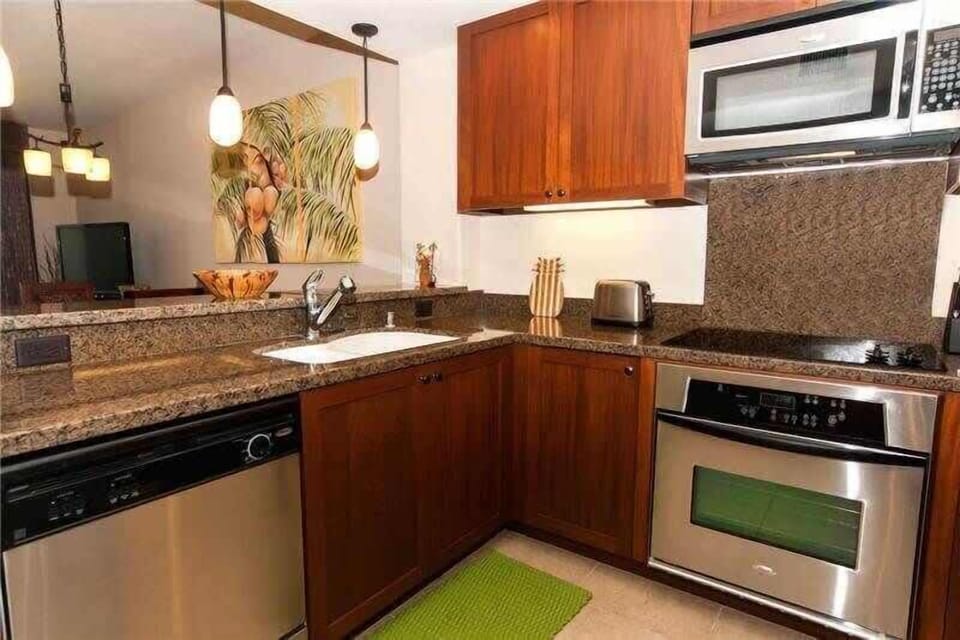 Cook with ease in this fully equipped kitchen featuring granite counters, rich wood, and sleek steel.

