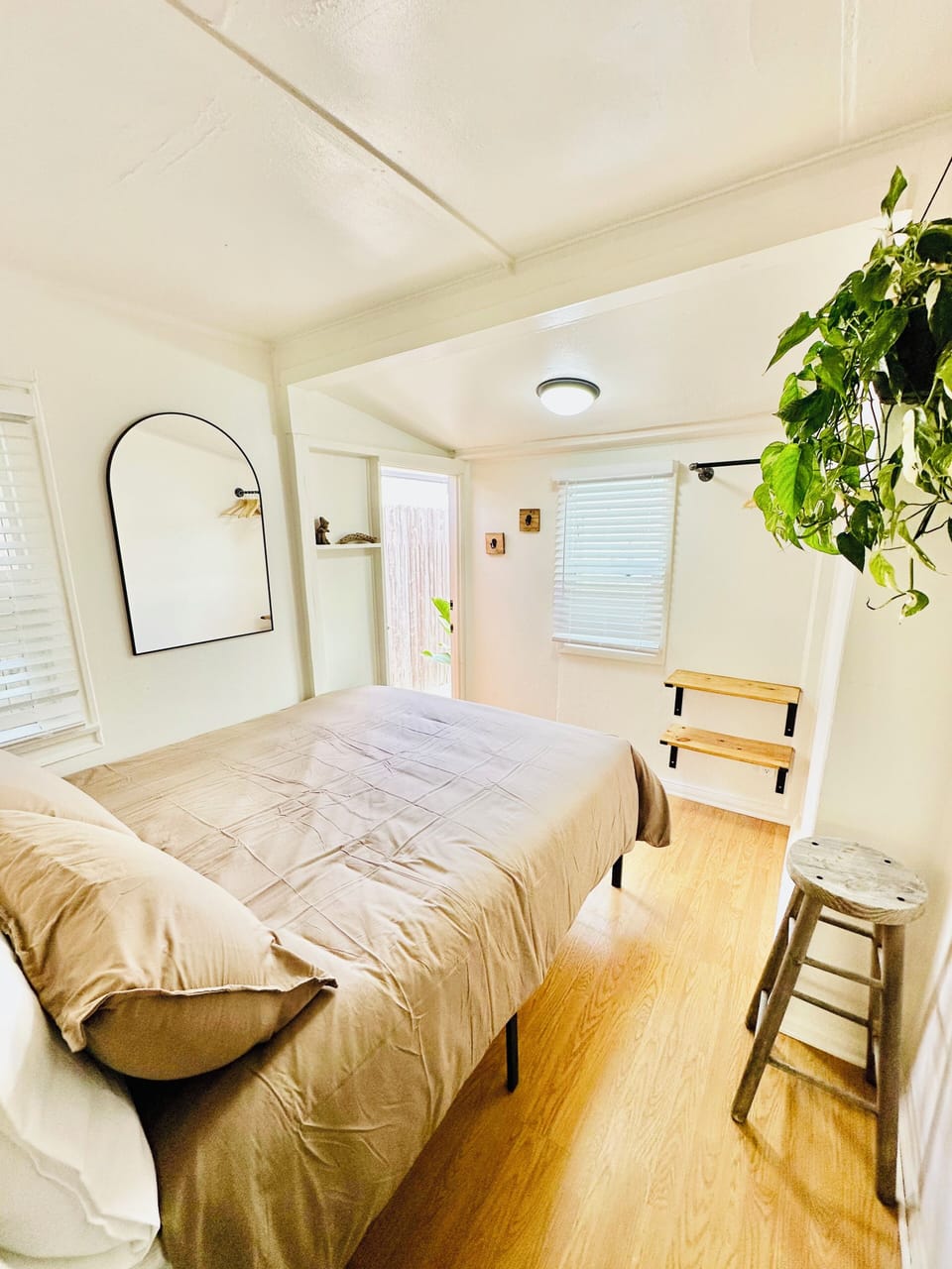 Bedroom space with doors leading to bathroom & back patio.