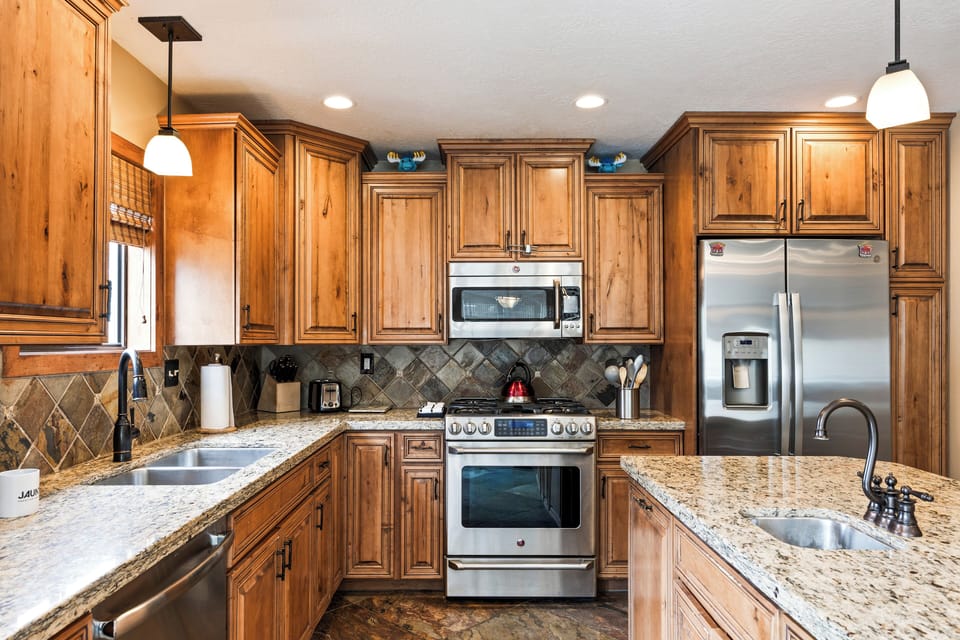 - Sleek kitchen with natural wood finishes and tile backsplash  
- Gas stove and stainless appliances designed for everyday use  
- Pendant lighting adds warmth and charm to the space