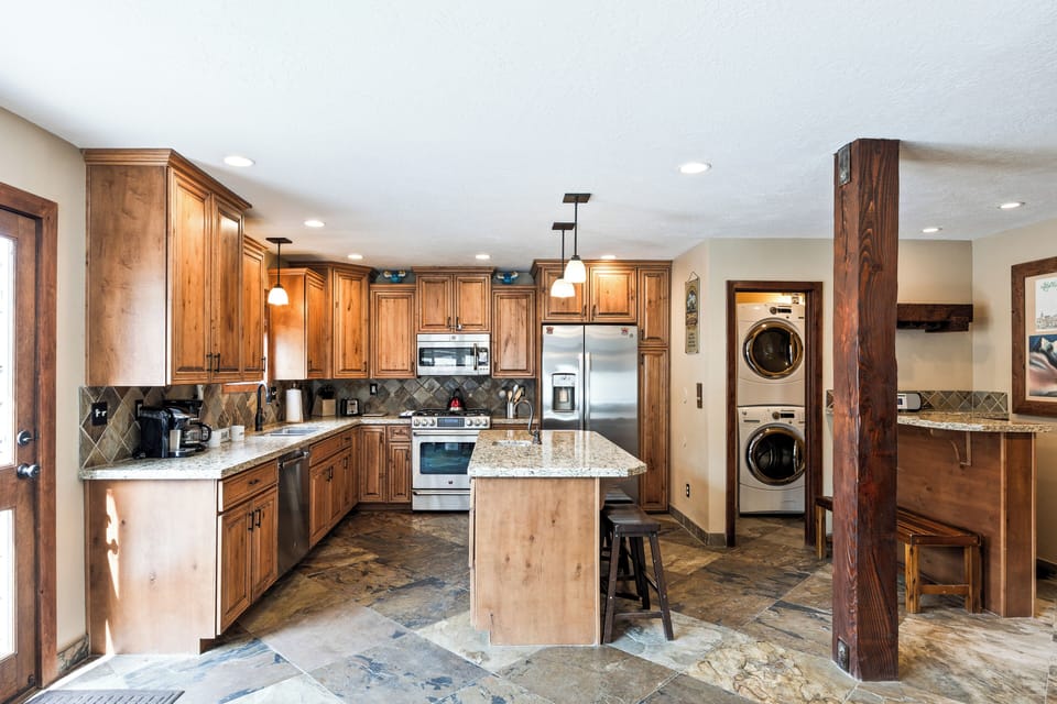 - Spacious kitchen with granite counters and stainless steel appliances  
- Fully equipped for cooking meals with island seating and modern design  
- Convenient laundry nook with washer dryer for extended stays