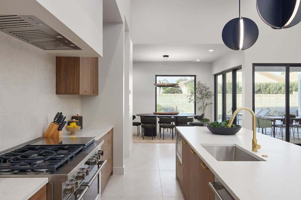 Unit 1: Fully equipped chefs kitchen featuring a colossal kitchen island offering an abundance of counter space with bar seating, high-end stainless steel appliances and stocked with all culinary essentials.