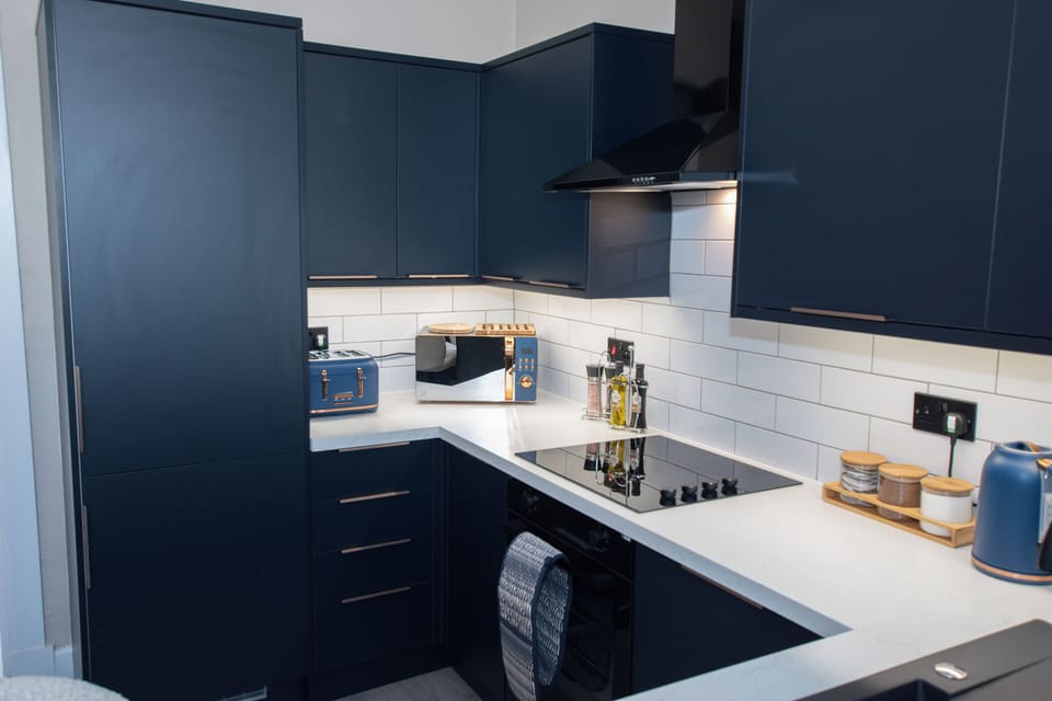 This stylish designer kitchen features sleek copper handles, premium appliances including a dishwash