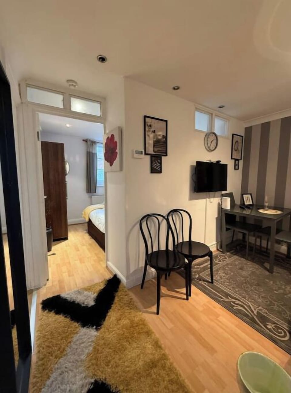 Relax in a bright, comfortable living room featuring a plush sofa, flat-screen TV, and stylish decor. Large windows let in natural light, creating a warm and inviting atmosphere perfect for unwinding or entertaining.