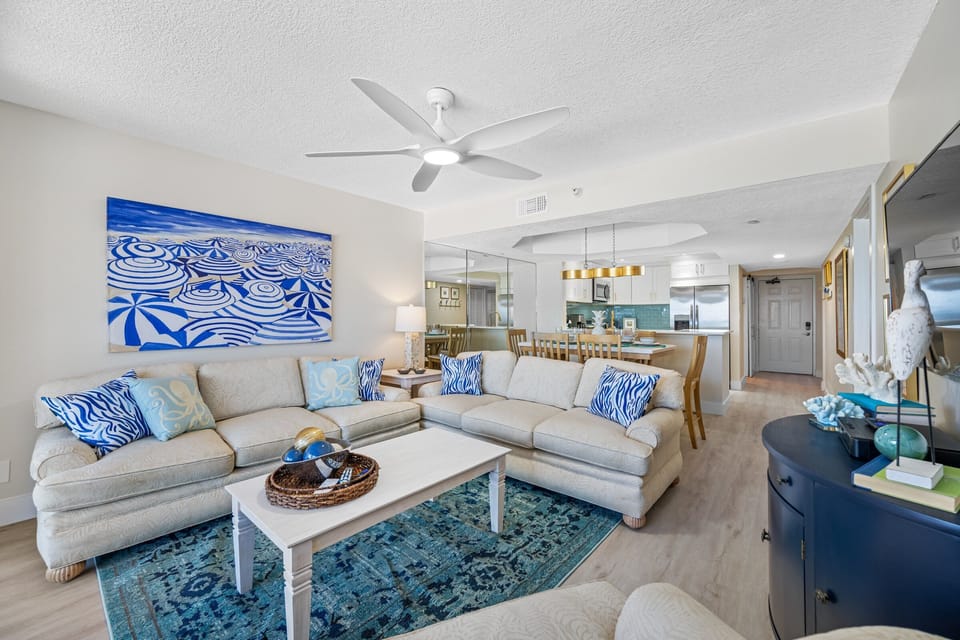 Open-plan living area with plush seating and beach-inspired decor.