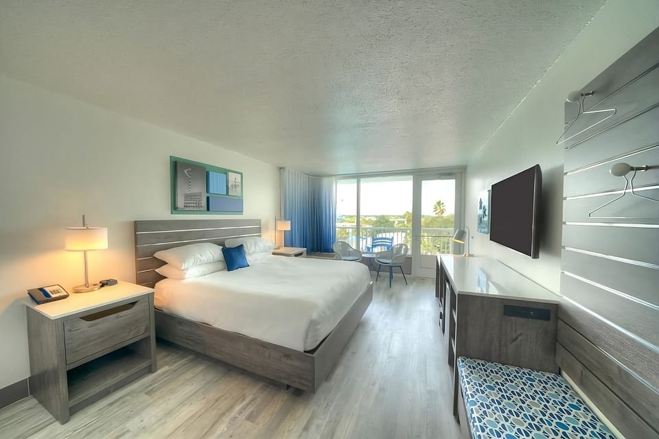 Step into a sunlit king room opening to the balcony.