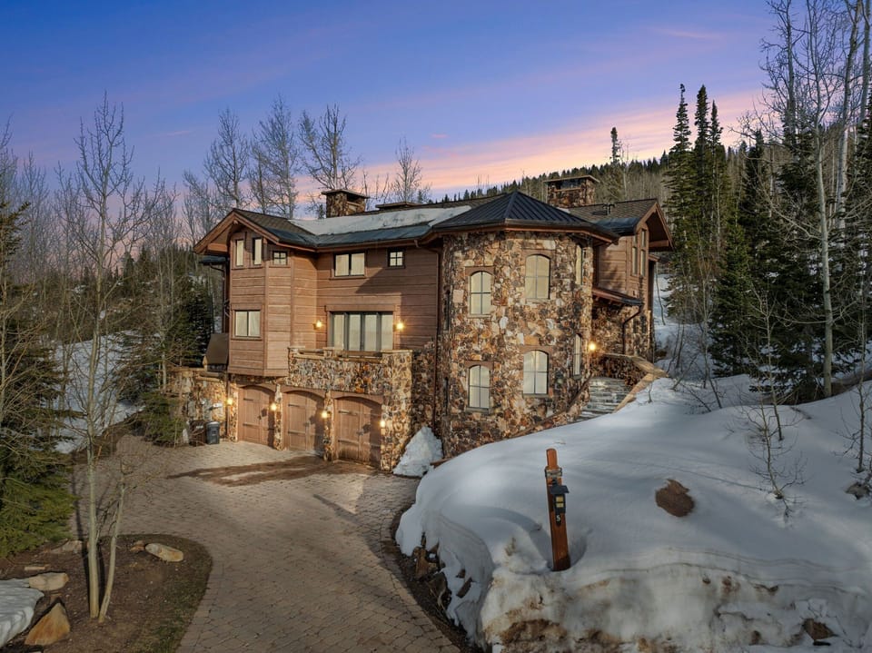 Ski Utah Home from the exterior, the home is luxurious and stands tall with mountains and sunset behind it