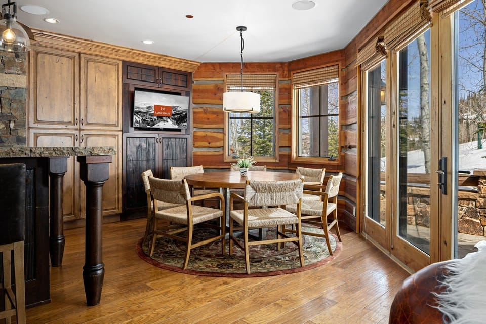 Dining nook in the kitchen with stylish chairs and a TV which says Luxe Haus