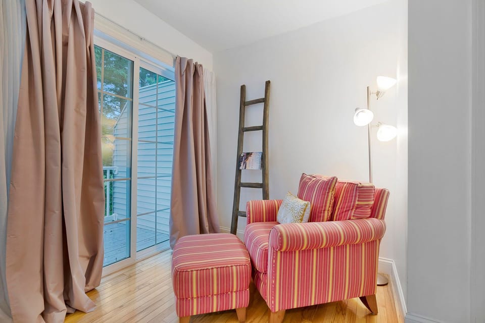 Unwind in the cozy reading nook, featuring a plush armchair and direct sliding door access to the private deck.