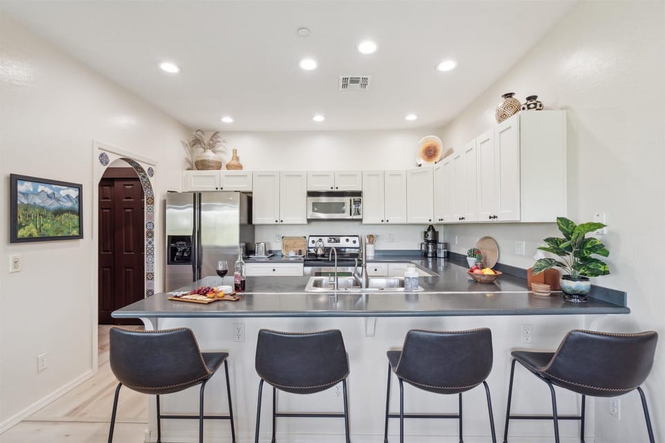 The Kitchen showcases a clean look, stainless steel appliances, and bar seating for four in a stylish, functional layout.