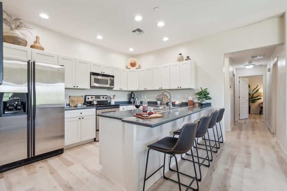 The Kitchen showcases a clean look, stainless steel appliances, and bar seating for four in a stylish, functional layout.