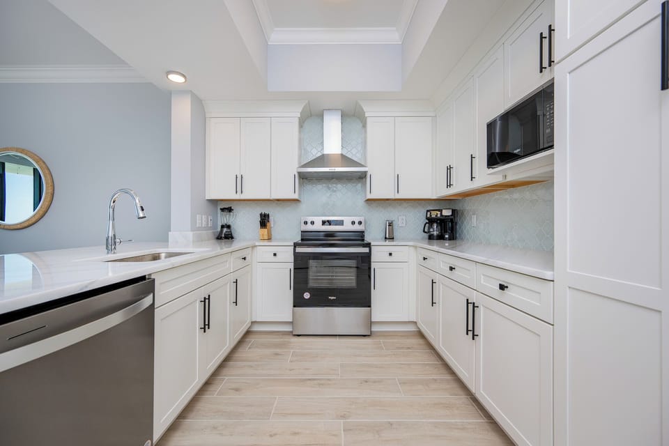 Prepare meals in this stylish kitchen featuring sleek cabinetry, stainless appliances, and elegant design