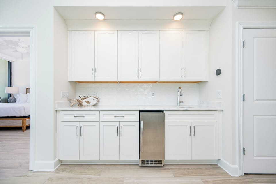 Pour a drink from the wet bar with sleek cabinetry, modern appliances, and a decorative fish accent