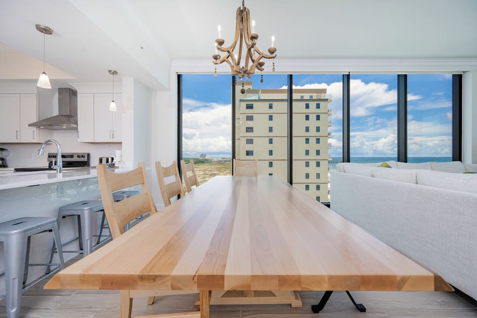 Gather around the spacious wooden dining table, enjoying stunning coastal views through large windows