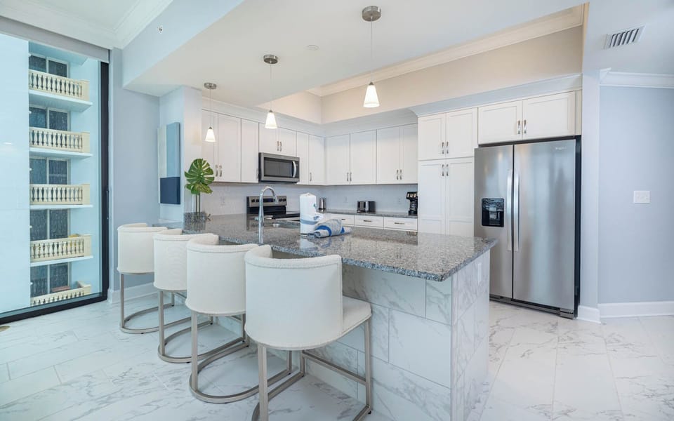 Gather around the stylish bar with plush seating, perfect for morning coffee in this inviting kitchen space