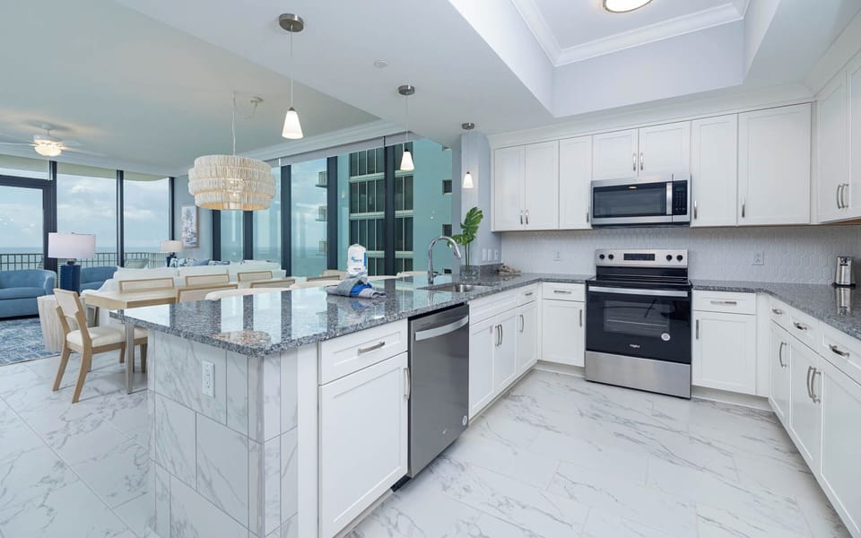 Prepare meals in this stylish kitchen with sleek countertops, stainless appliances, and elegant accents