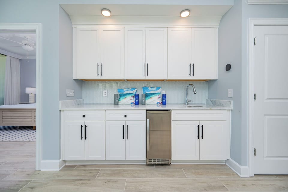 Pour a drink from the wet bar with stylish cabintry and elegant backsplash