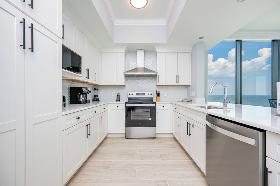 Prepare meals with ease in this stylish kitchen featuring stainless appliances and a beachfront view