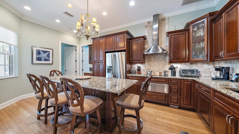 Large kitchen with stainless steel appliances and kitchen island with plenty of seating
