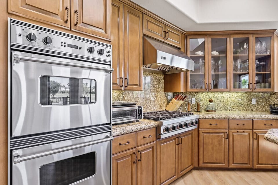Close-up of double wall ovens & detailed cabinetry for a polished cooking space