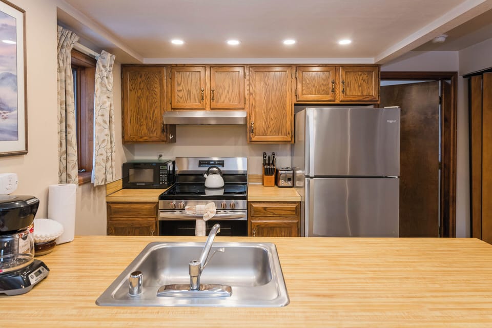 Your fully equipped kitchen awaits with warm wood cabinets, stainless appliances, and everything you need to create memorable meals during your stay.