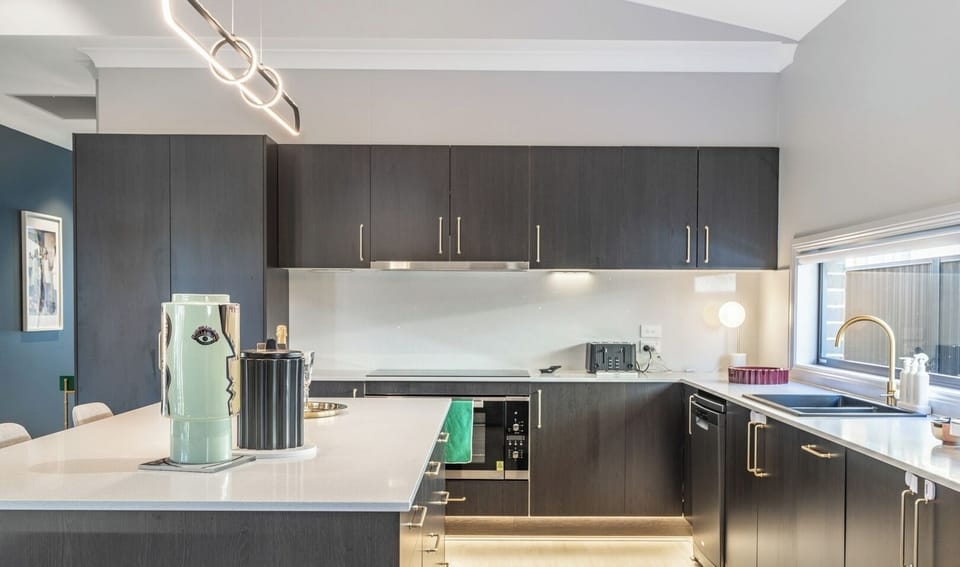 A streamlined and efficient kitchen workspace featuring dark cabinetry and clean surfaces.