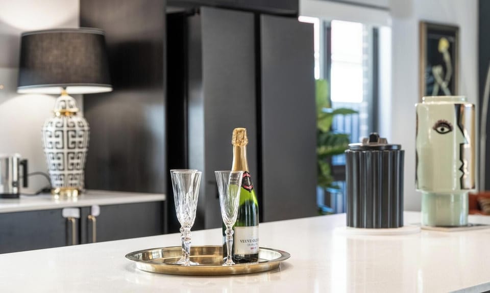 A pristine and polished kitchen island topped with a celebratory champagne setup.