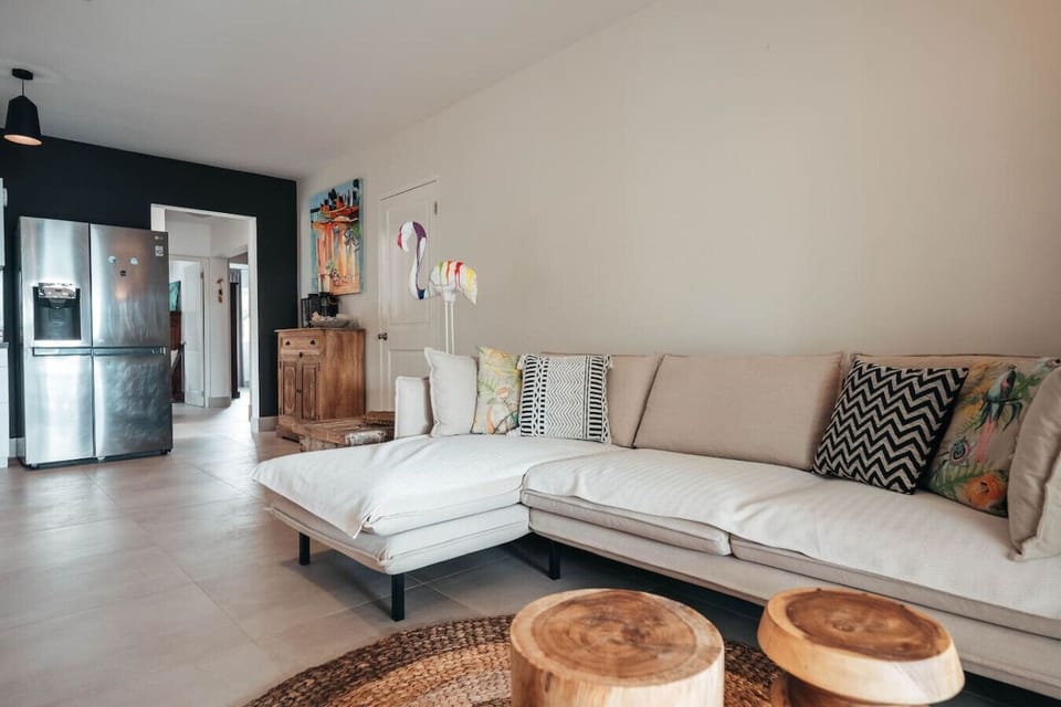 A modern living room featuring a sleek sofa paired with stylish wood center tables, creating a warm yet contemporary space perfect for relaxing and entertaining.