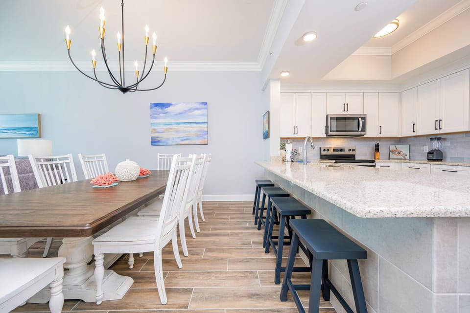 Elegant dining table, complemented by coastal decor and a spacious kitchen for meal prep