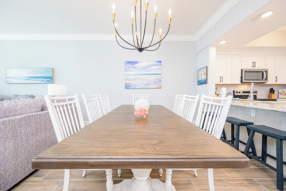 Gather around the spacious dining table, surrounded by stylish chairs and vibrant coastal decor