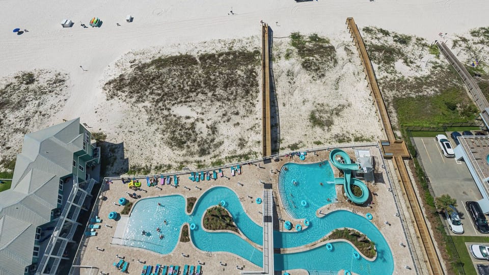 Discover the inviting pool area with gradual entry, a refreshing lazy river, and fun waterslide on the beach