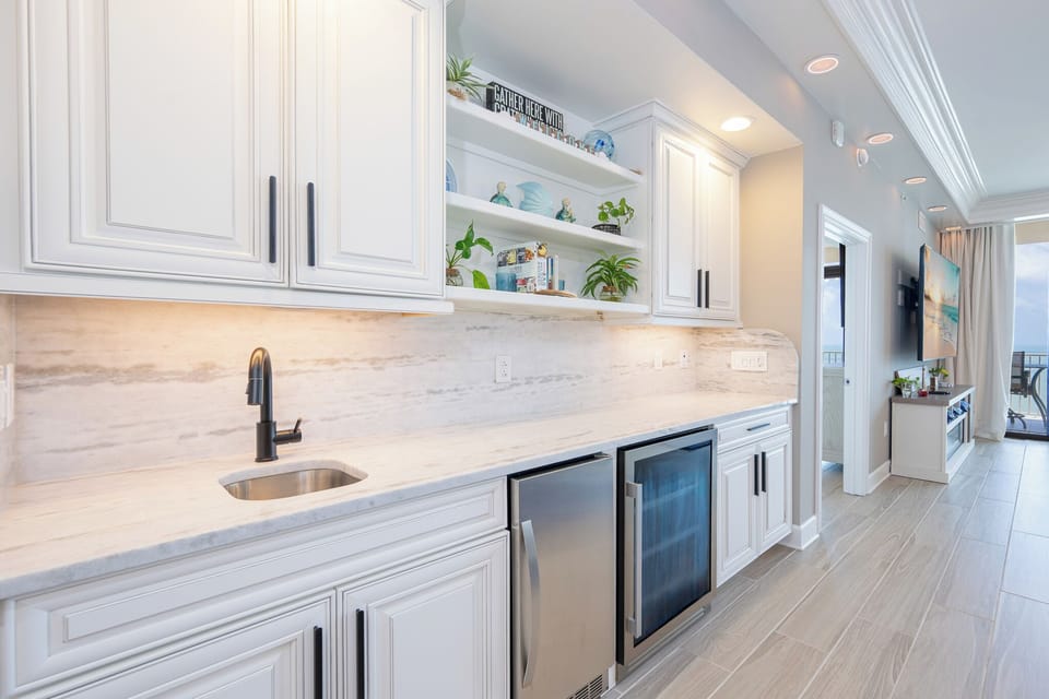 Enjoy preparing drinks at the wet bar with a wine cooler and coastal accents