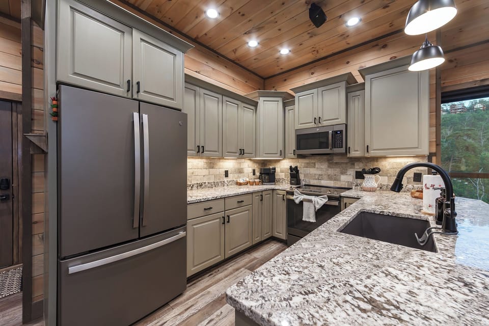 Slate GE stainless steel appliances in kitchen and granite countertops. 