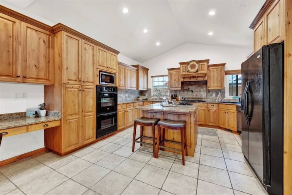 Chef’s kitchen fully stocked with cookware, dishes, and utensils—featuring granite countertops, double ovens, a gas stove top, and everything you need to whip up meals for a crowd. (2)