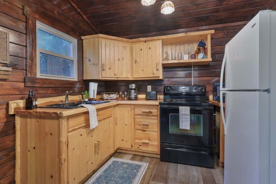 Charming cabin kitchen w/ wood cabinetry, stove, fridge & everything needed for simple meals