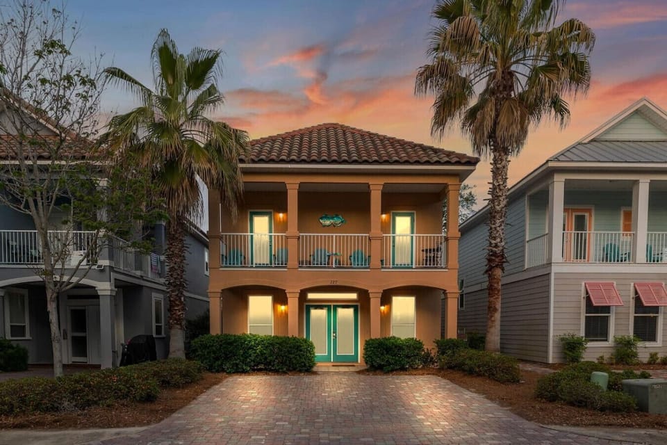 This charming two-story beauty with its warm terracotta facade and turquoise doors is basically the definition of `So Stinkin Cute` the moment you pull up to that brick driveway.