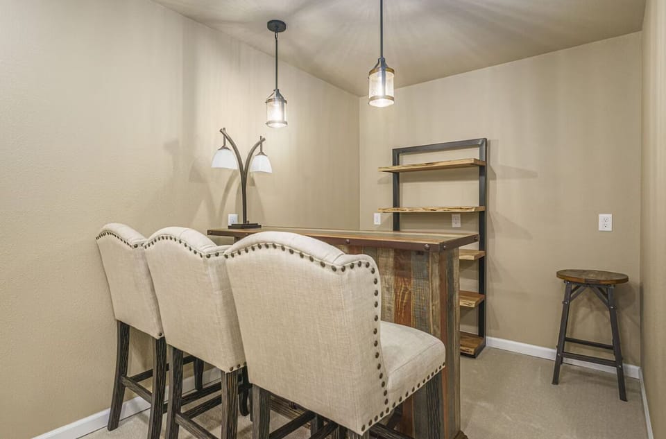 - Stylish bar area with high back chairs, pendant lights, and a rustic wood counter invites conversation
- Great space for hosting casual hangouts or enjoying a quiet drink
- Open shelving gives you room to stock up for any occasion