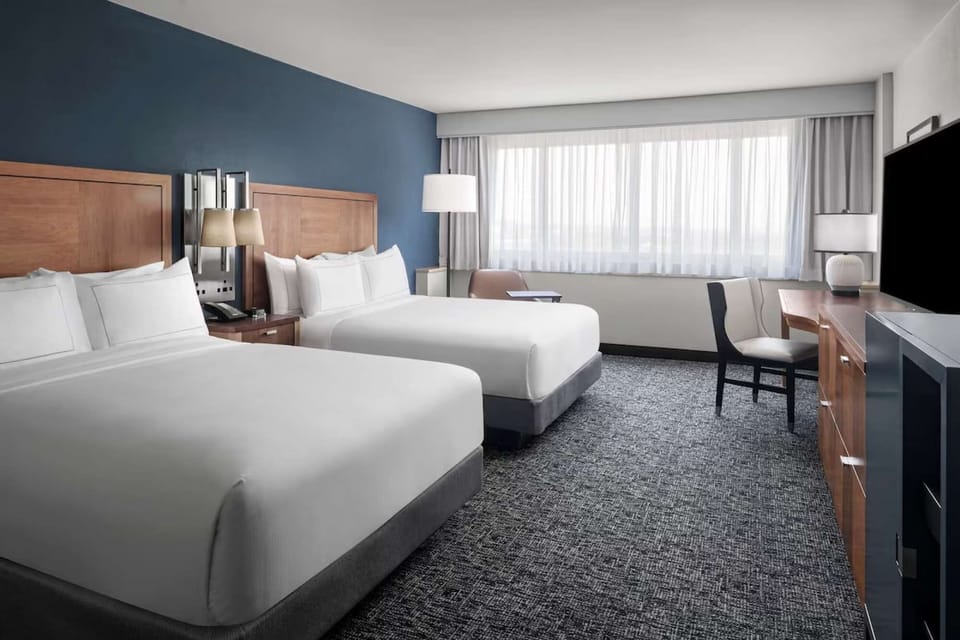 Bright room with two queen beds, desk, and large window view