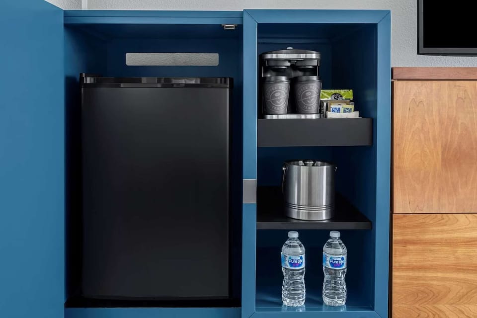 Mini fridge with coffee maker, ice bucket, and bottled water