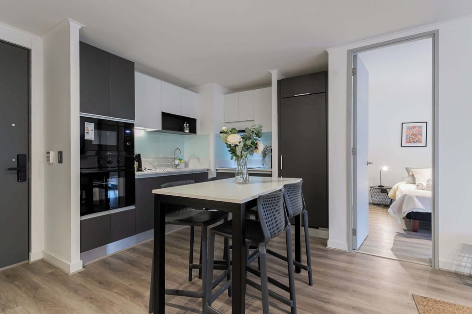 Sleek modern kitchen with dining area, perfect for cozy meals. Enjoy the seamless flow into the inviting bedroom.