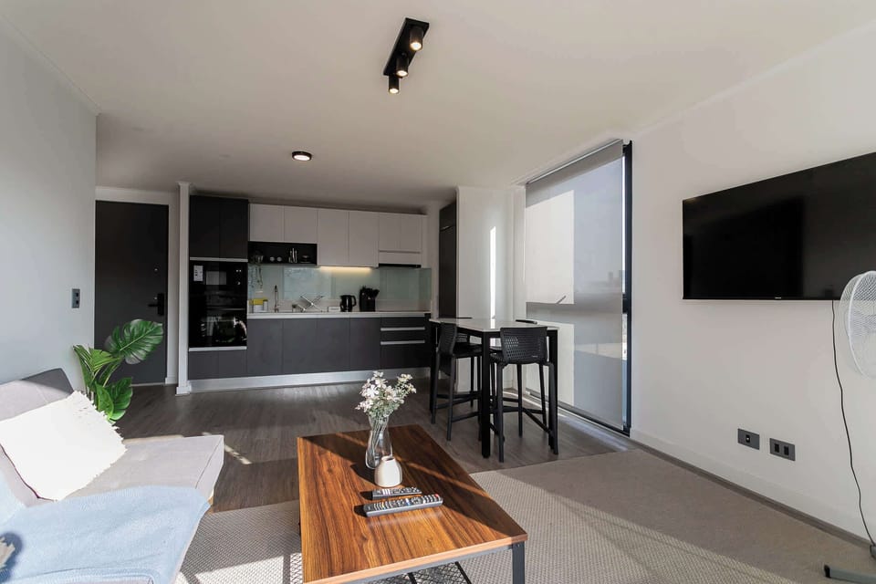 Experience modern comfort in this stylish open-plan living area with a sleek kitchen and abundant natural light.