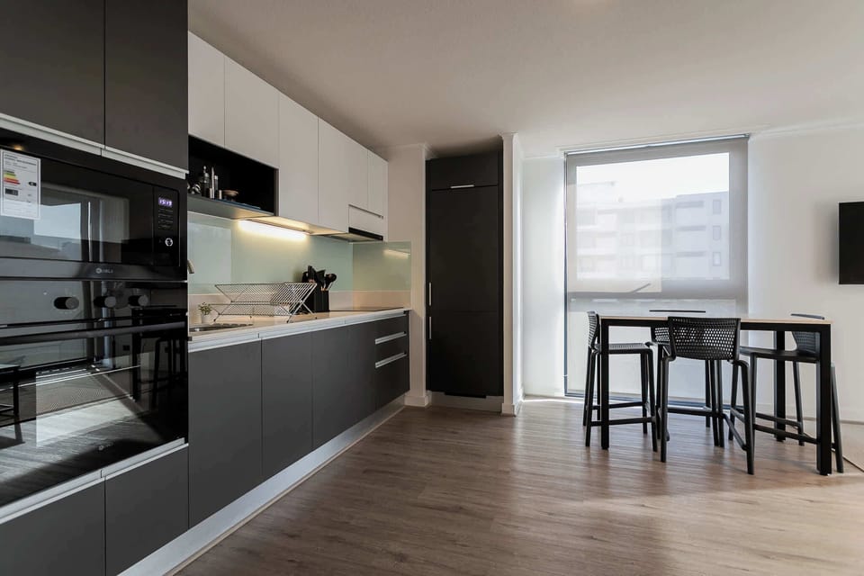 Experience culinary delight in this sleek, modern kitchen with ample natural light and stylish dining area.