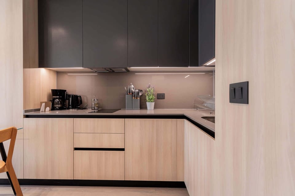 Experience modern living in this sleek kitchen, featuring stylish cabinetry and essential appliances for a comfortable stay.